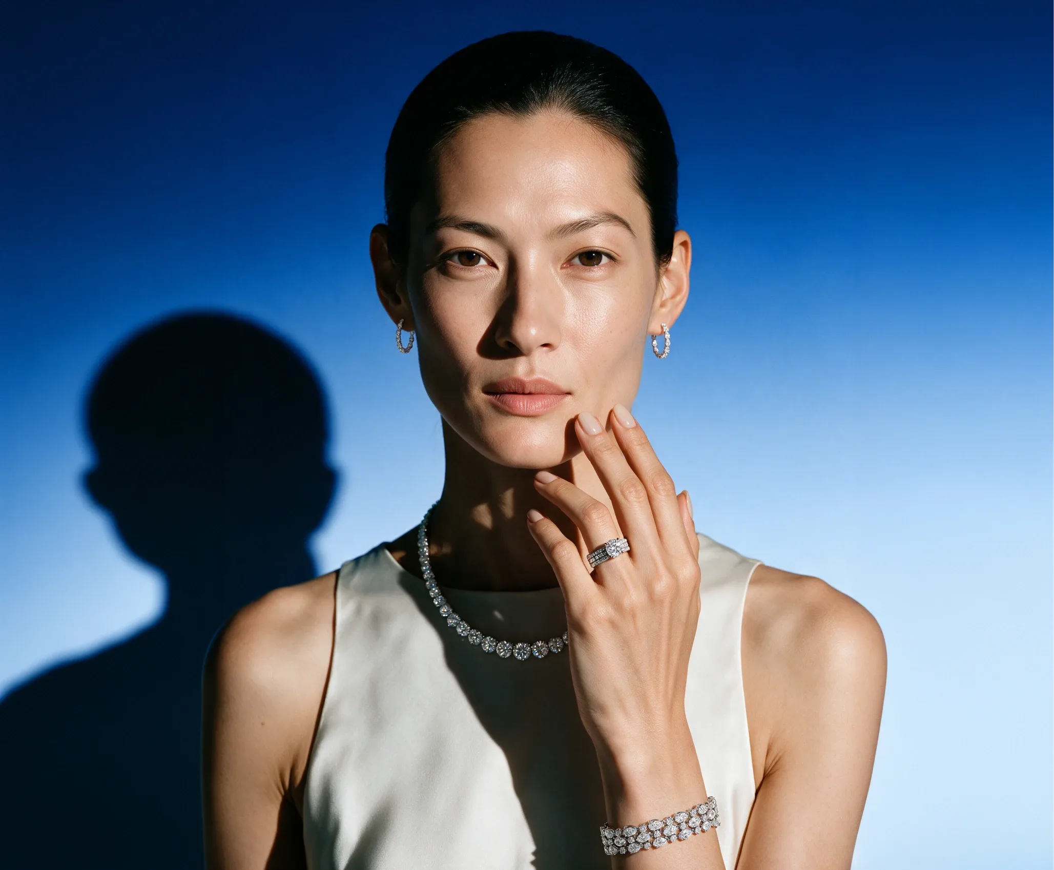 Model wearing a diamond rivière necklace, bracelet and ring